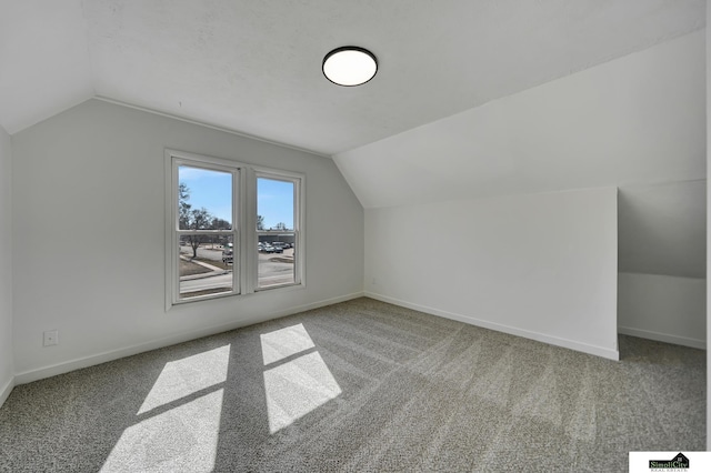 bonus room with carpet, baseboards, and vaulted ceiling