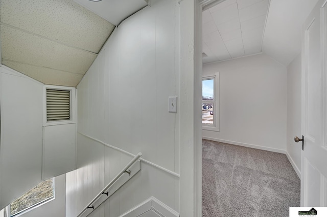 interior space featuring vaulted ceiling, baseboards, and carpet floors