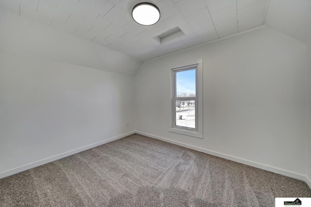 interior space featuring vaulted ceiling, carpet flooring, and baseboards