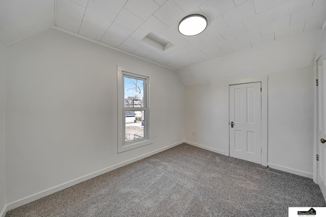 spare room with baseboards, carpet, and vaulted ceiling