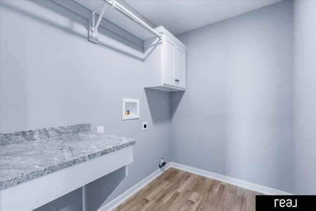 washroom with electric dryer hookup, light wood-type flooring, washer hookup, cabinet space, and baseboards