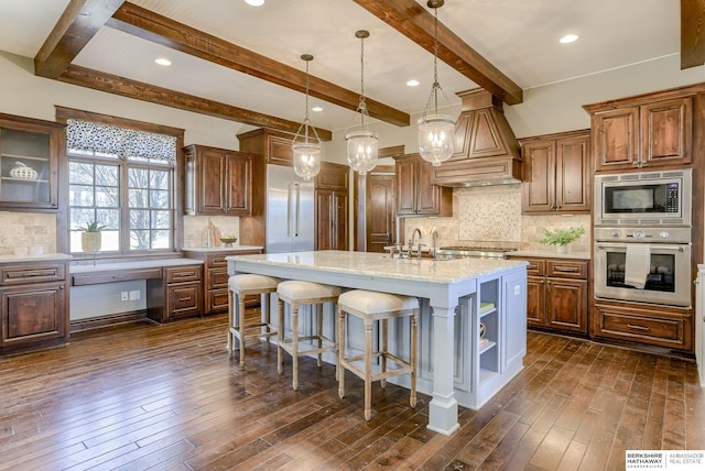 kitchen featuring a breakfast bar area, premium range hood, dark wood finished floors, stainless steel appliances, and backsplash