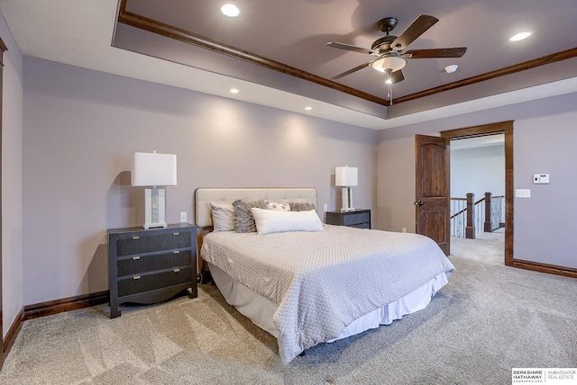 bedroom with a tray ceiling, carpet flooring, baseboards, and ornamental molding