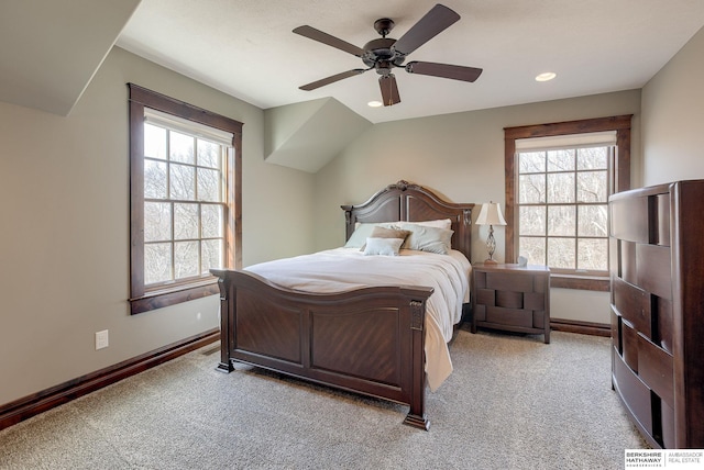 bedroom featuring multiple windows, light colored carpet, and baseboards