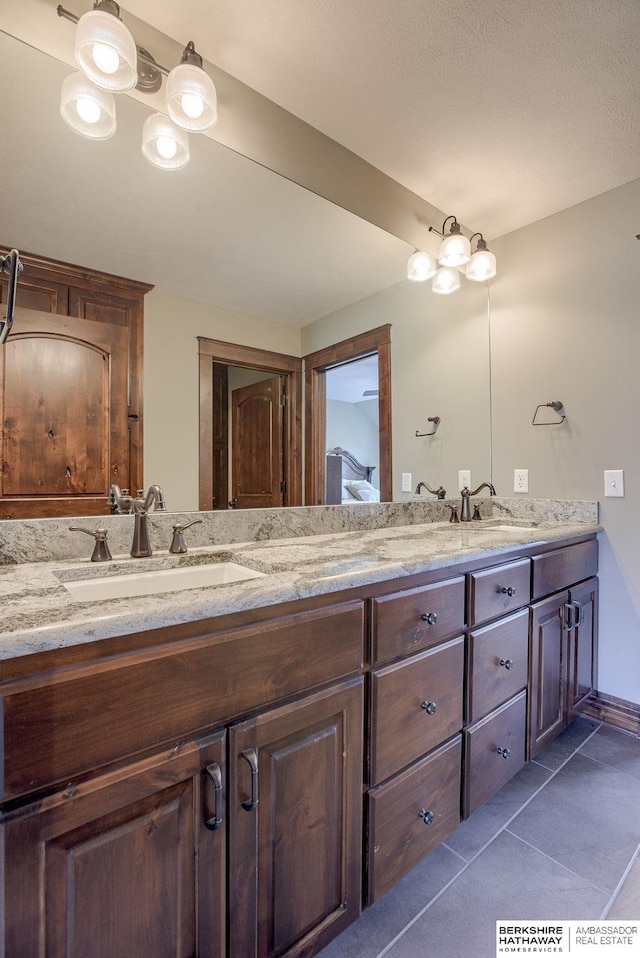 bathroom with double vanity, tile patterned flooring, and a sink