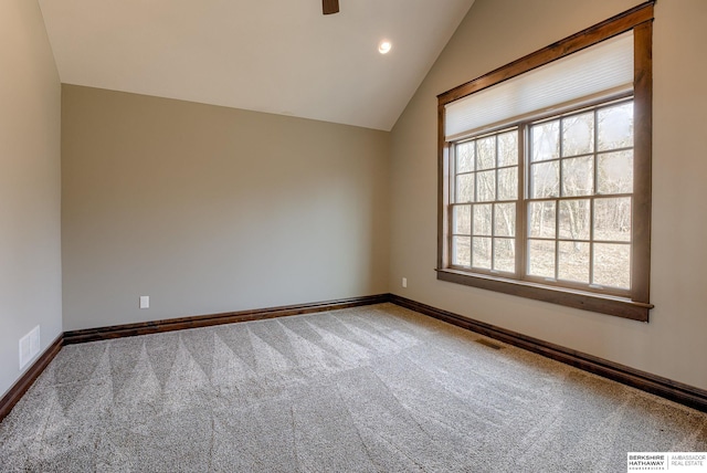 spare room featuring a wealth of natural light, visible vents, lofted ceiling, and carpet floors