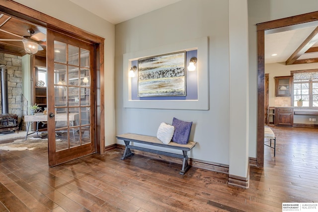 living area featuring beamed ceiling, baseboards, and dark wood-style flooring