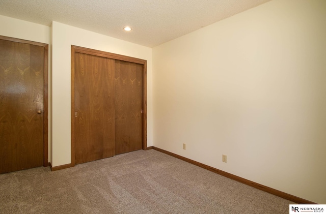 unfurnished bedroom with recessed lighting, baseboards, carpet, and a textured ceiling