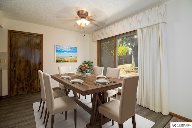 dining area with baseboards, a textured ceiling, wood finished floors, and a ceiling fan