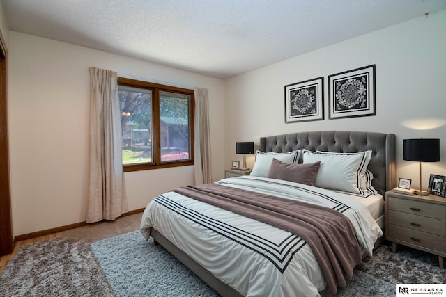 carpeted bedroom with a textured ceiling and baseboards