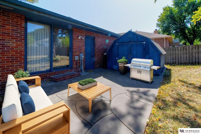 view of patio with area for grilling, a shed, fence, an outdoor structure, and an outdoor hangout area