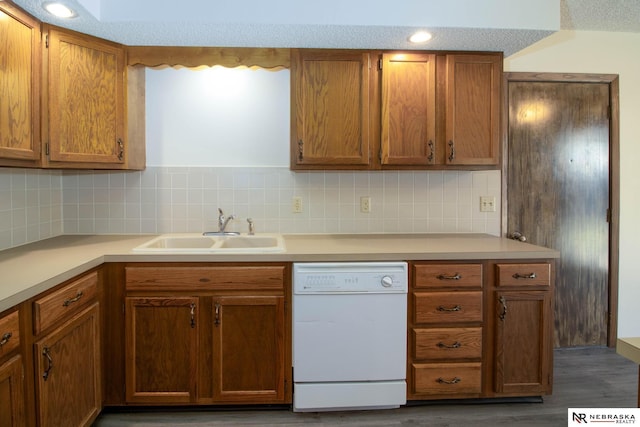 kitchen with a sink, backsplash, light countertops, and white dishwasher