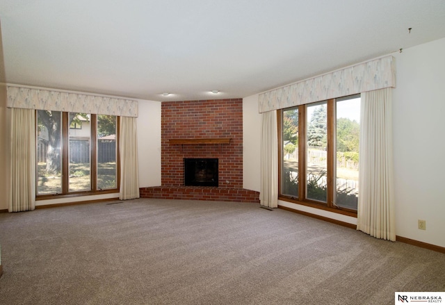 unfurnished living room with a brick fireplace, carpet flooring, and a healthy amount of sunlight