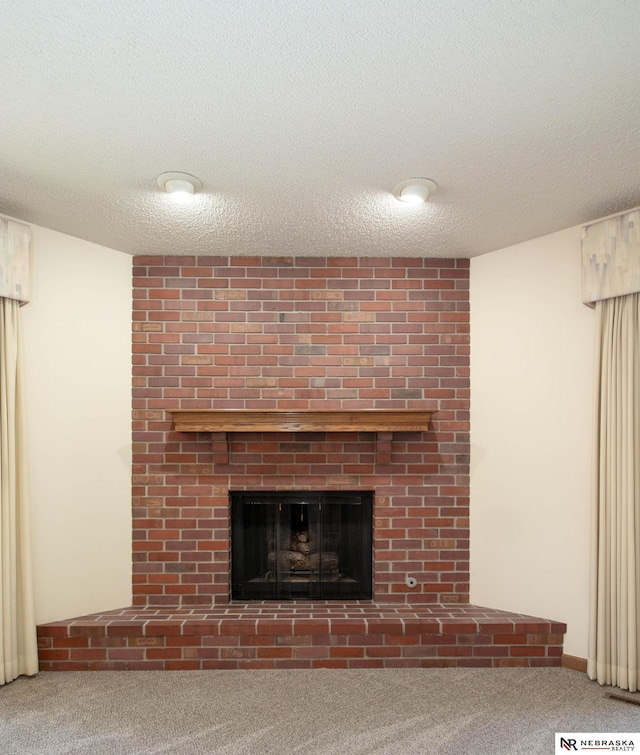 interior details featuring carpet, a brick fireplace, and a textured ceiling