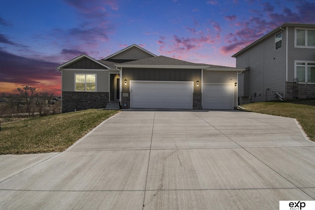 ranch-style home featuring driveway, stone siding, board and batten siding, a front lawn, and a garage