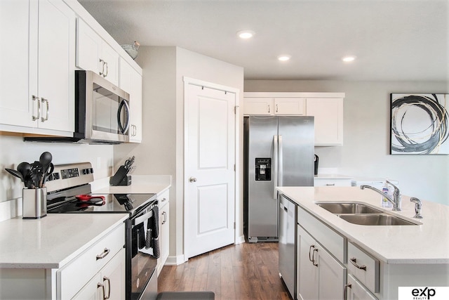 kitchen with a sink, appliances with stainless steel finishes, dark wood-style floors, white cabinetry, and recessed lighting
