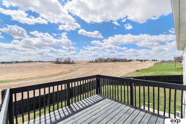 wooden deck featuring a rural view, a yard, and fence