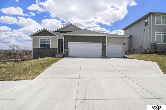 view of front facade featuring stone siding, a garage, board and batten siding, concrete driveway, and a front lawn