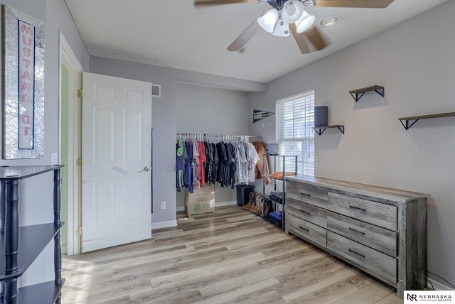 bedroom featuring a ceiling fan, wood finished floors, visible vents, and baseboards