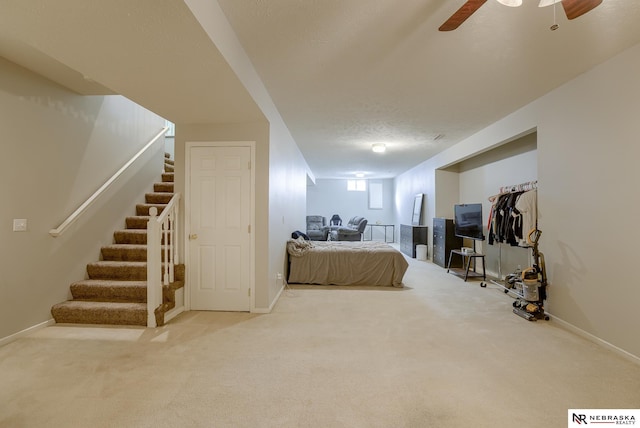 carpeted bedroom featuring baseboards, a textured ceiling, and ceiling fan