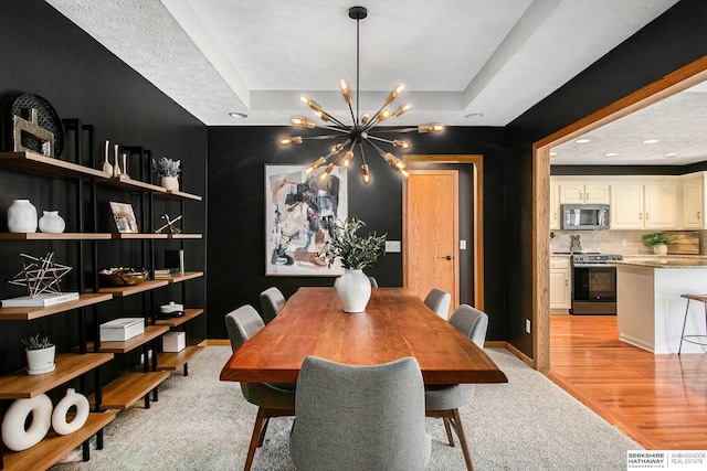 dining room with recessed lighting, light wood-type flooring, baseboards, and a notable chandelier