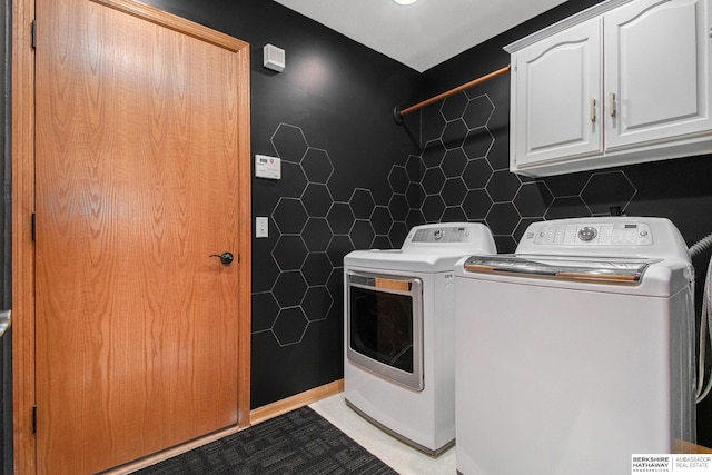 laundry room featuring tile walls, washing machine and dryer, and cabinet space