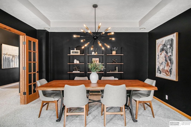 carpeted dining area featuring a textured ceiling, visible vents, baseboards, and a chandelier