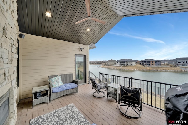 wooden terrace with a residential view, a water view, area for grilling, and ceiling fan