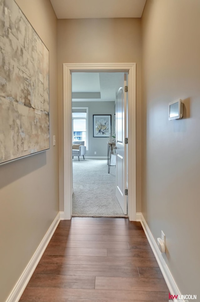 hallway with baseboards and wood finished floors