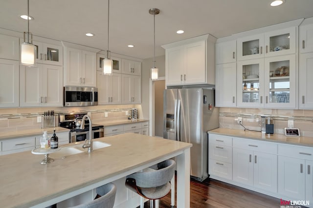 kitchen featuring white cabinetry, a breakfast bar area, appliances with stainless steel finishes, and pendant lighting