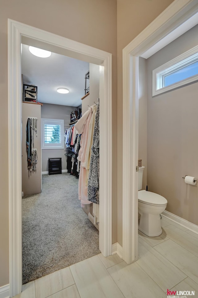 bathroom featuring toilet and baseboards