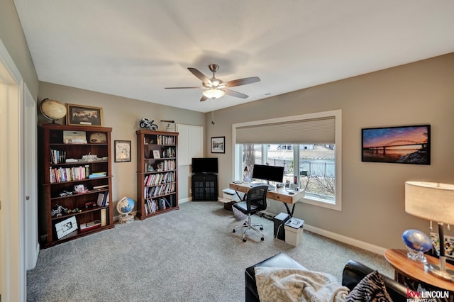 carpeted home office with baseboards and ceiling fan