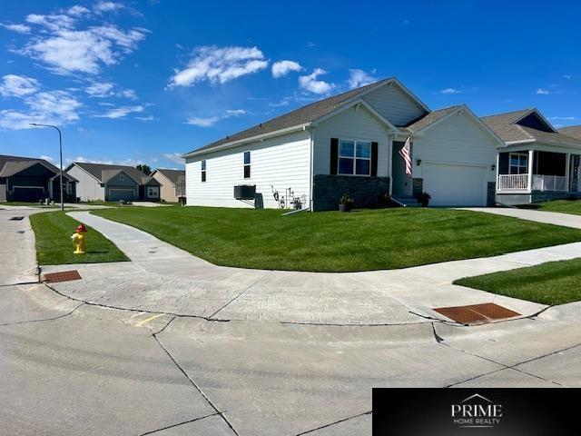 view of front of property with a residential view, an attached garage, concrete driveway, and a front yard