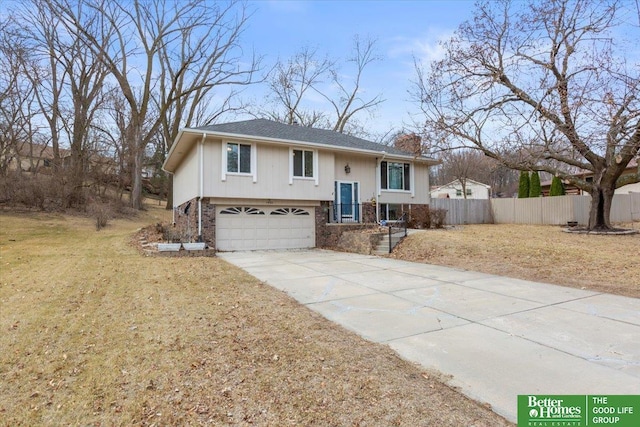 split foyer home with brick siding, fence, concrete driveway, a chimney, and a garage