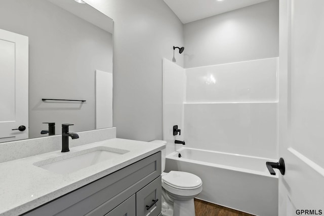 bathroom with toilet, vanity, shower / tub combination, and wood finished floors