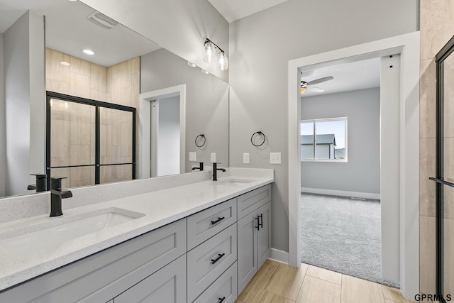 bathroom featuring a sink, tiled shower, and ceiling fan