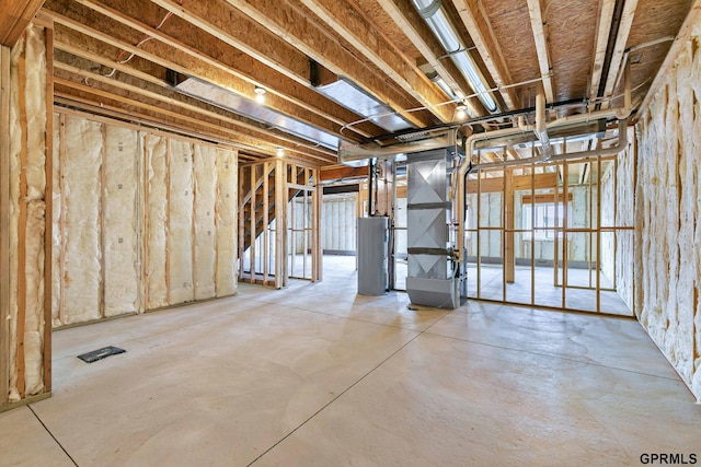 unfinished basement featuring water heater and heating unit