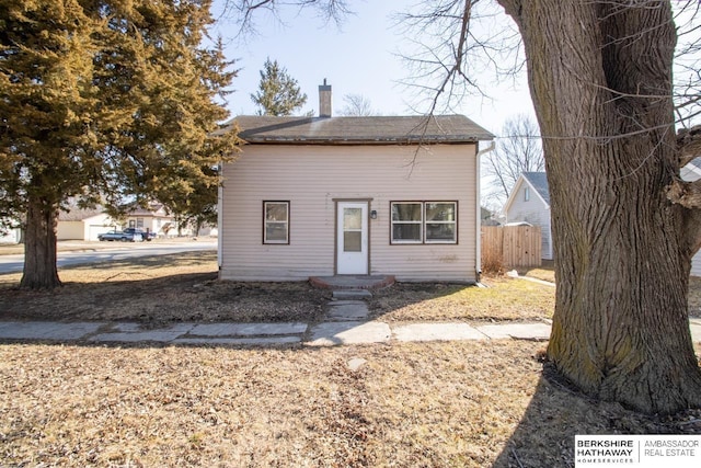 view of front of home featuring a chimney and fence