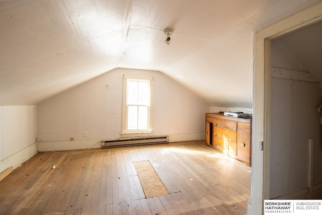 additional living space featuring a baseboard heating unit, vaulted ceiling, and wood-type flooring