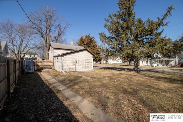 view of yard with a storage unit, an outdoor structure, and fence