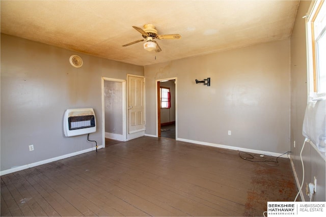 unfurnished room featuring heating unit, baseboards, ceiling fan, and wood-type flooring