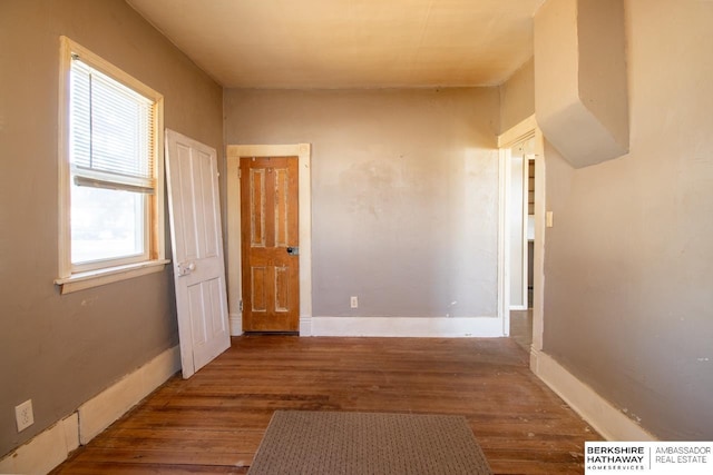 hallway with baseboards and wood finished floors