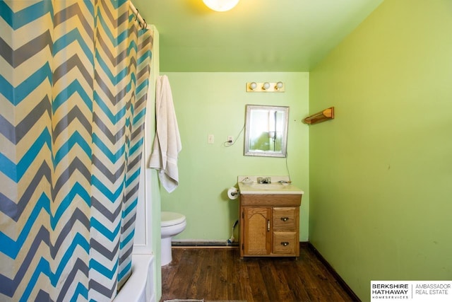 bathroom featuring curtained shower, baseboards, toilet, wood finished floors, and vanity