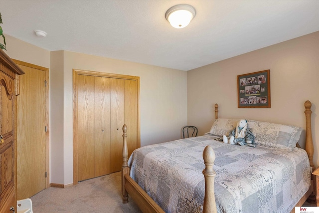 bedroom with a closet, light colored carpet, and baseboards