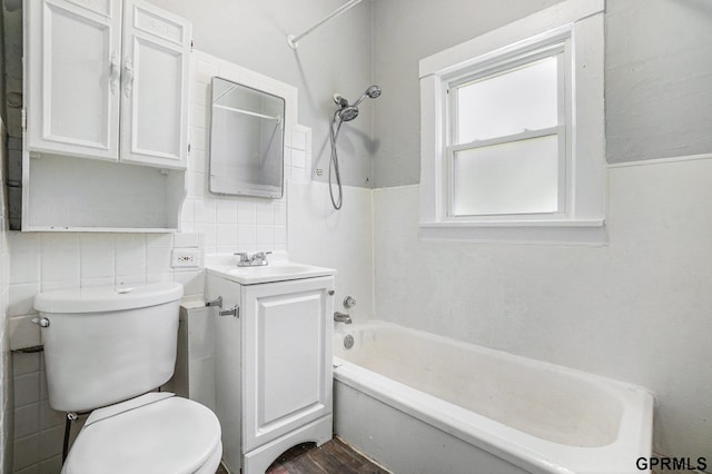 bathroom with toilet, tile walls, wood finished floors, vanity, and tub / shower combination