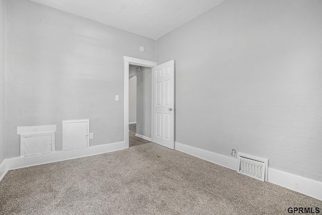 carpeted empty room featuring visible vents and baseboards