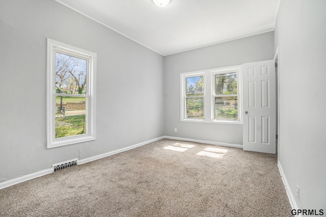 carpeted empty room with baseboards, a healthy amount of sunlight, and visible vents