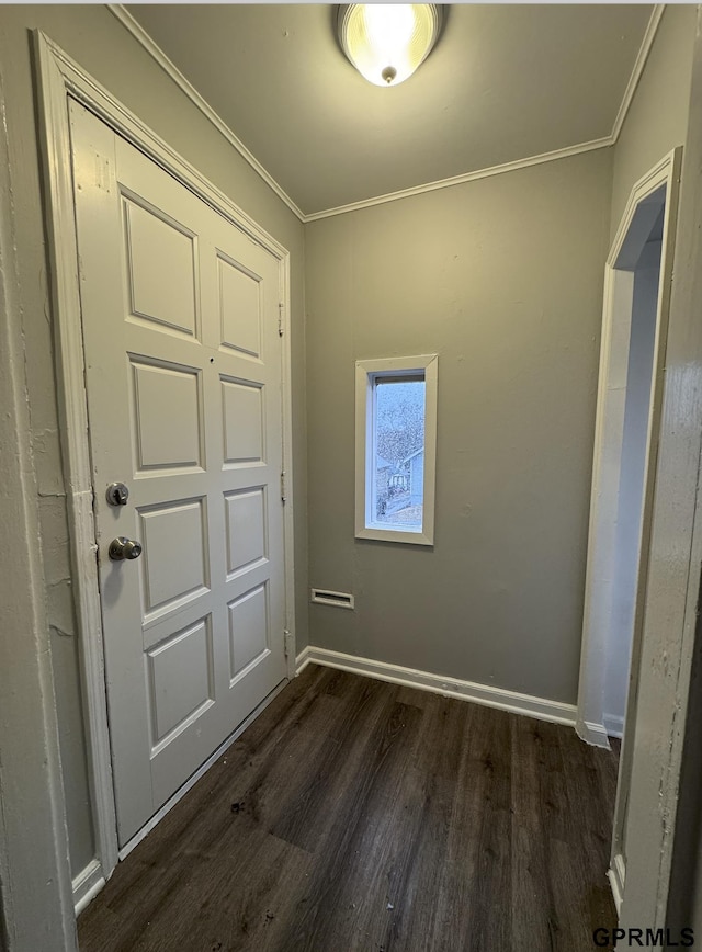 unfurnished bedroom featuring crown molding, dark wood-style floors, a closet, and baseboards