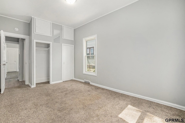 unfurnished bedroom with a closet, visible vents, carpet flooring, and baseboards