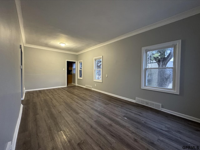 unfurnished room with visible vents, baseboards, dark wood-style floors, and ornamental molding